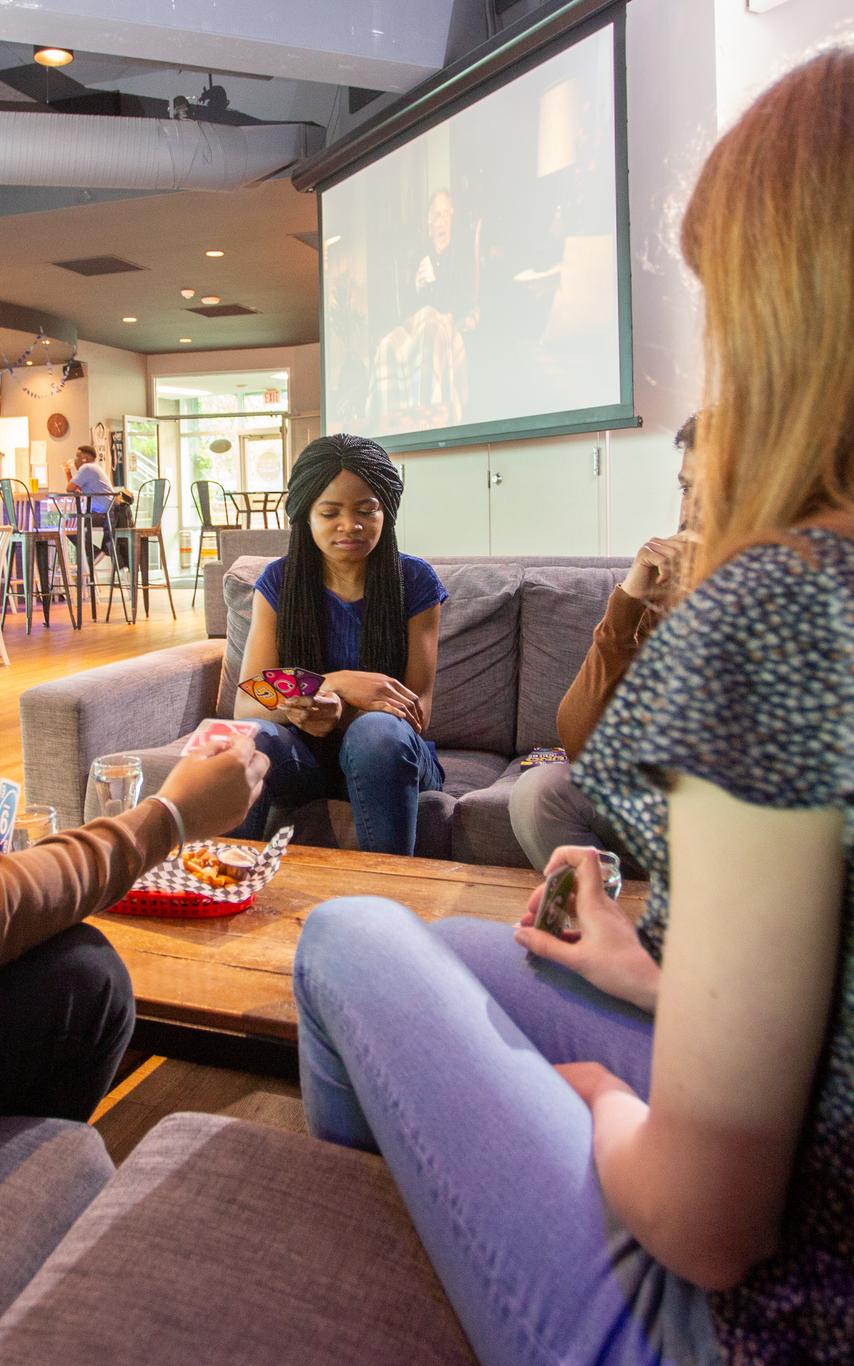 Three students sitting at a table eating nachos. 